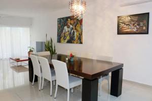 a dining room with a table and white chairs at Oasis del Sol in Playa del Carmen