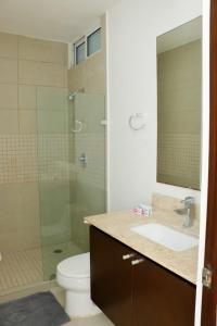 a bathroom with a shower and a sink and a toilet at Oasis del Sol in Playa del Carmen