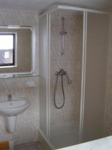 La salle de bains est pourvue d'une douche et d'un lavabo. dans l'établissement Apartmán Schovánek, à Harrachov