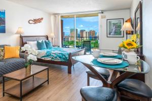 a living room with a bed and a table in a room at Renovated Condo Near Waikiki Beach in Honolulu