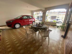 a car parked in a garage with a table and chairs at Casa na Cidade Nova in Ananindeua +5 photos