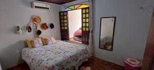 a bedroom with a bed and a window and a mirror at Casa na Cidade Nova in Ananindeua