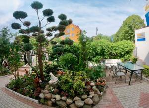 a garden with a small tree and a table and chairs at Dom Gościnny Wika in Rewal