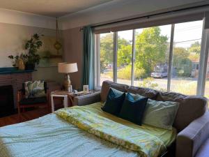 a living room with a couch and a large window at Mid-Century Modern Apartment at Horner Park in Victoria