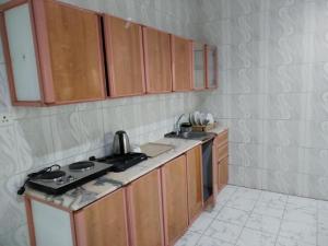 a kitchen with wooden cabinets and a stove top oven at السراج للشقق المخدومة in Jeddah