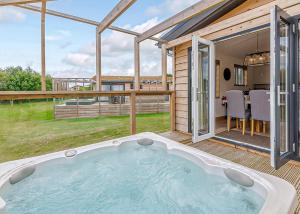 a hot tub on the deck of a house at Cherry Bird Country Park in Newbury