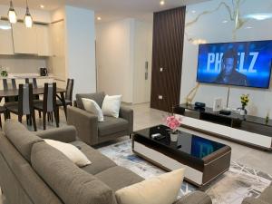 a living room with a couch and a tv on a wall at Nova luxe 2 Bed Executive Stay in Accra