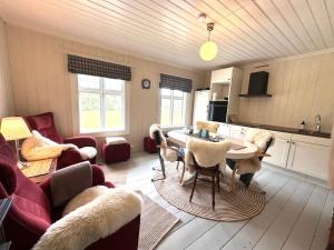 a living room with a table and a kitchen at Nord-Garthus, leilighet 2 in Hølera
