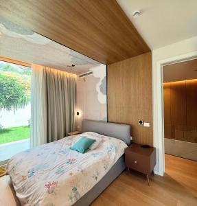 Un dormitorio con una cama y una ventana grande. en Green Coast Premium Villa, en Palasë