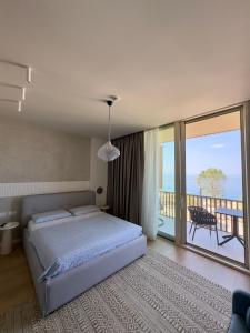 Un dormitorio con una cama y un balcón. en Green Coast Premium Villa, en Palasë