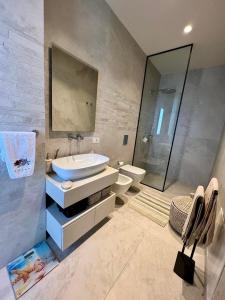 un baño con lavabo e inodoro en Green Coast Premium Villa, en Palasë