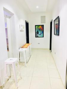 a room with two white stools and paintings on the walls at 3Apartments in Lagos