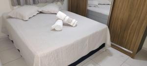 a bed with two rolled towels on top of it at Apto 2 quarto completo com vaga-proximo shopping contagem in Contagem