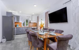a dining room with a table and chairs and a refrigerator at Beautiful Home In Pinezici With Kitchen in Pinezici