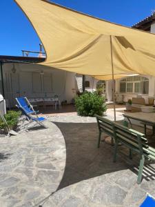 a large yellow umbrella on a patio with a table and chairs at casa l'olivo in Forio d'Ischia