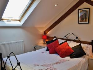 a bedroom with a bed with red and black pillows at Fenn House in Alvechurch