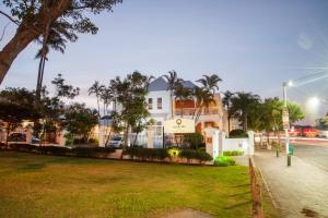 una casa blanca con palmeras frente a una calle en Quarters Hotel, en Durban