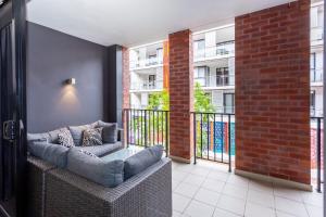 a balcony with a couch and a brick building at Subiaco Rooftop on Sheen in Perth