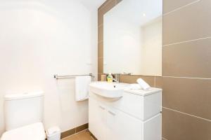 a white bathroom with a sink and a toilet at Subiaco Rooftop on Sheen in Perth +6 photos