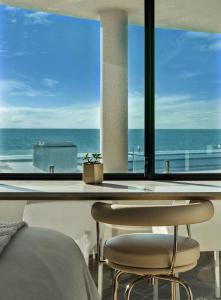 a bedroom with a bed and a view of the ocean at Cottesloe Neue Blue Apartment in Perth