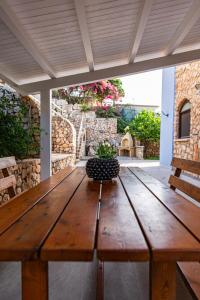 a wooden table with a potted plant on a patio at Villa Luna Scopello in Castellammare del Golfo