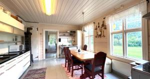 a kitchen with a table and chairs in a room at Nord-Garthus gård leilighet 1 in Hølera