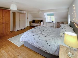 ein Schlafzimmer mit einem großen Bett und einer Couch in der Unterkunft Sandy Toes Cottage in Beechamwell