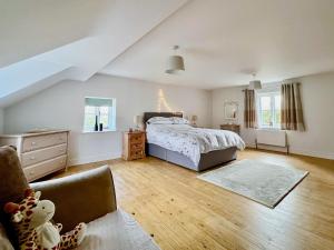 ein Schlafzimmer mit einem Bett und einem Stuhl darin in der Unterkunft Sandy Toes Cottage in Beechamwell