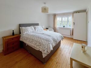 ein Schlafzimmer mit einem Bett und einem Tisch und einem Fenster in der Unterkunft Sandy Toes Cottage in Beechamwell + 12 Fotos