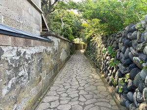 a stone path next to a stone wall at Hav Living in Oshima