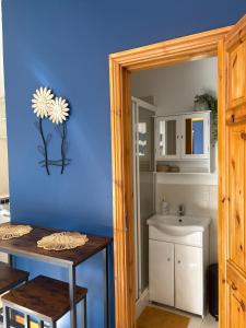 a bathroom with a blue wall and a sink at The Cabin At The Lodge in Naas
