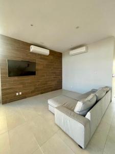 a living room with a couch and a flat screen tv at Fantástico Depa en BLUU con PLAYA ARTIFICIAL - Turquesa 208 - in Mazatlán