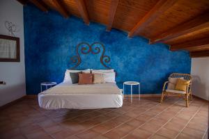 a bedroom with a bed with a blue wall at Villa Luna Scopello in Castellammare del Golfo +106 photos