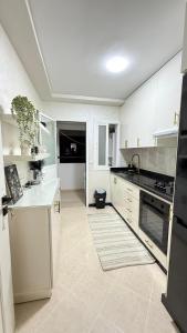a kitchen with white cabinets and a white counter top at BARAKA APPART in Selouane