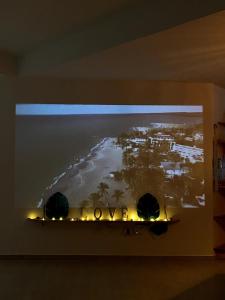 a television hanging on a wall with a picture of a island at El Yaque Flow Beach, tu apartamento de playa in El Yaque +22 photos
