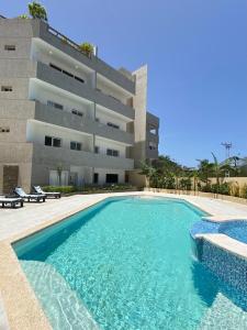 a swimming pool in front of a building at El Yaque Flow Beach, tu apartamento de playa in El Yaque