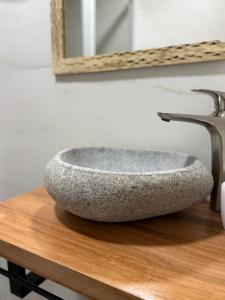 ein Steinwaschbecken auf einer Holzablage in einem Badezimmer in der Unterkunft Hotel Jireh in San Pedro de Atacama + 21 Fotos