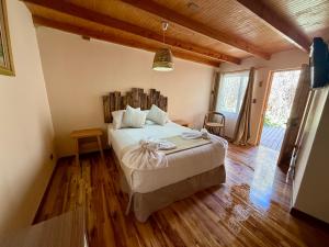ein Schlafzimmer mit einem großen Bett mit hölzernem Kopfteil in der Unterkunft Hotel Jireh in San Pedro de Atacama