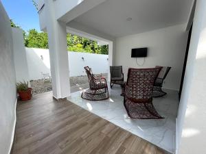 a living room with two chairs and a television at Casahermosa in Santo Domingo