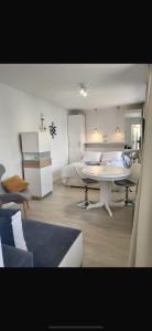 a living room with a bed and a table in a room at Pokoje 100 m od morza in Dziwnów