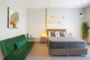Un dormitorio con una cama y un sofá verde. en Central Belgrade Apartments on Square, en Belgrado