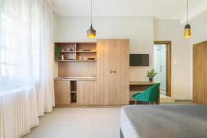 Un dormitorio con una cama y una silla verde. en Central Belgrade Apartments on Square, en Belgrado