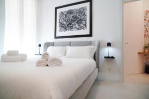 a bedroom with a white bed with towels on it at Mama suites Politeama in Palermo