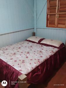 a large bed in a blue room with avertisement at Cabanas altos da glória in Rolante
