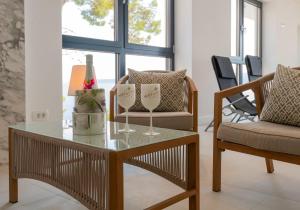 a living room with a table and two glasses of wine at Beautiful Seafront Split Villa 9 Bedrooms Bellamar Vista Retreat Large Heated Infinity Pool & Jacuzzi Makarska in Makarska
