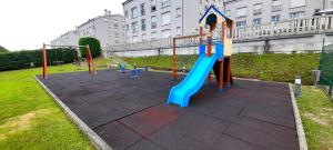 a playground with a blue slide in a park at Apartamento Playa Catedrales & Piscina I in San Pedro de Benquerencia