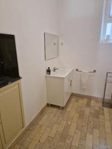 a white bathroom with a sink and a mirror at Casa 7 in Setúbal