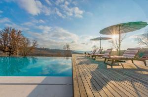 two chairs and an umbrella next to a swimming pool at Tranquil Istria Estate Palazio Clai Winery 8 Bedrooms Spa & Heated Pool in Grožnjan