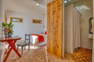 a bedroom with a bed and a table and a wooden door at Casa Paloma - Lakefront - Waterfalls - Gardens in San Marcos La Laguna +36 photos
