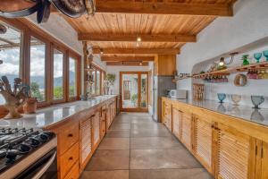 a kitchen with wooden cabinets and a counter top at Casa Paloma - Lakefront - Waterfalls - Gardens in San Marcos La Laguna